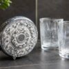 Douchette et verres marqués par des traces blanches, scène domestique montrant les effets visibles d’une eau dure