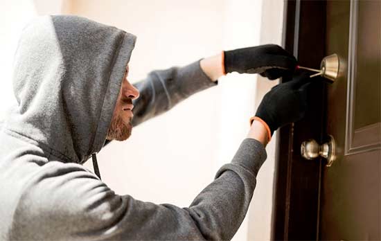 cambrioleur en train de forcer une serrure de porte