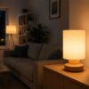 Photo d’un salon vide en soirée, une lampe d’appoint connectée allumée près d’un canapé, lumière chaude et douce